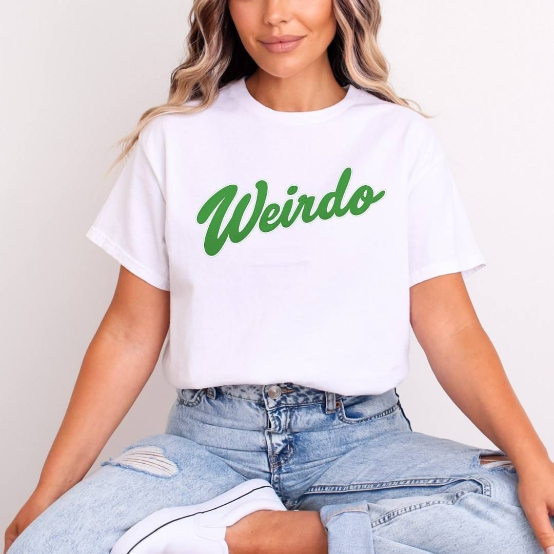 Person wearing a white slogan t-shirt with 'Weirdo' in green text and ripped jeans.